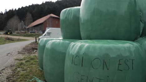 green-hay-balls-container-in-Creux-Du-Van,-Neuchatel,-Switzerland
