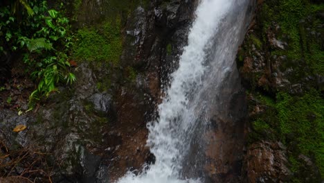 Slow-motion-tilting-up-shot,-scenic-view-of-water-pouring-down-the-la-Fortuna-waterfalls-in-the-rain-forest-of-Costa-Rica