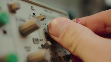 Nahaufnahme-Eines-Fingers,-Der-Einen-Schalter-Und-Einen-Knopf-Bedient-Und-Ein-Hochentwickeltes-Elektronisches-Vintage-Gerät-Manipuliert