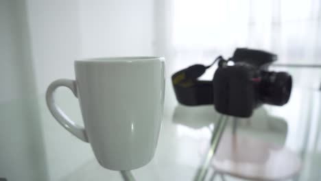 A-cup-of-coffee-and-a-camera-on-the-table,-waiting-for-the-person-who-goes-for-them