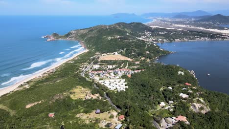 Aerial-drone-view-flying-over-tropical-city-with-lagoon-beach-and-atlantic-forest-in-tourist-area