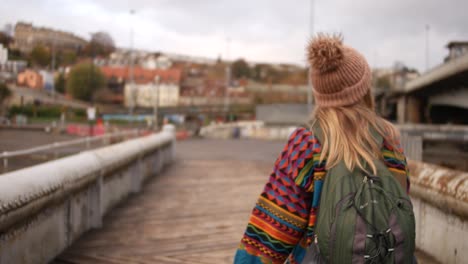 lady-in-colourful-clothing-crossing-a-bridge-in-Bristol-Uk