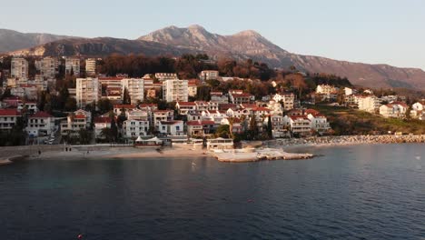 Aerial-view-of-small-coastal-town-built-in-beautiful-mountains-at-the-seaside