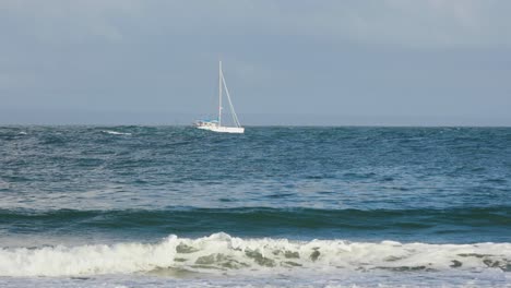 A-white-sailboat-is-moving-fast-on-the-waves-of-the-sea