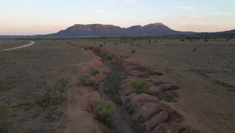Wilpena-Pound-in-distance,-Aerial-pullback-revealing-idyllic-Outback-Landscape
