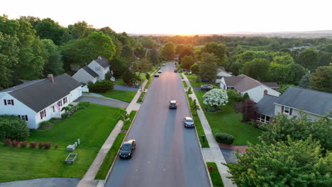 Aerial-tracking-shot-of-car-driving-down-neighborhood-street