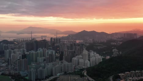 Toma-Aérea-De-La-Vista-De-La-Ciudad-De-Kowloon-Hong-Kong-Durante-El-Atardecer