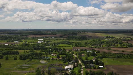 Hyper-lapse,-time-lapse-of-Farms-with-clouds-passing-over-head-with-a-scenery-landscape,-Forwarding-Aerial-Shot