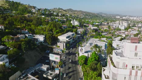Aerial-Drone-Shot-of-Sunset-Boulevard,-The-Strip-on-a-Sunny-California-Day,-Mountains-and-Chateau-Marmont-in-Distance