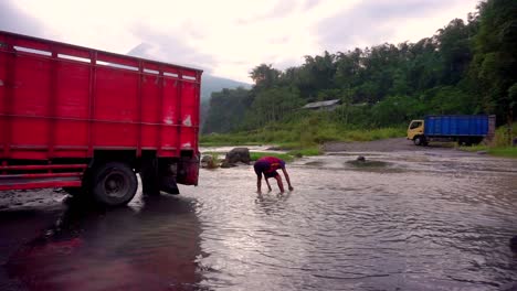 Close-up-shot-of-male-worker-picking-sand-out-of-river-and-put-on-truck-at-Bego-Pendem-in-Indonesia