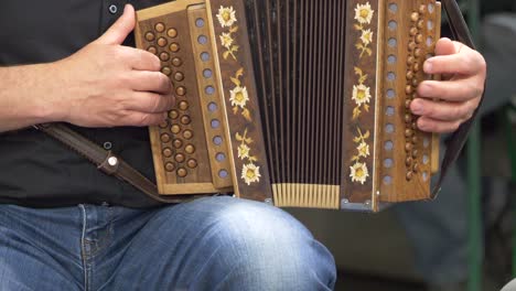 Close-up-shot-of-male-musician-playing-accordion-on-street-outdoors---slow-motion
