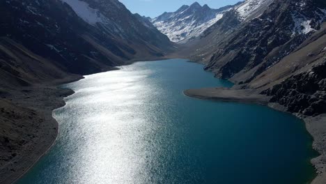 Aerial-jib-up-view-of-Laguna-del-Inca-in-the-Chilean-Andes-on-a-sunny-day
