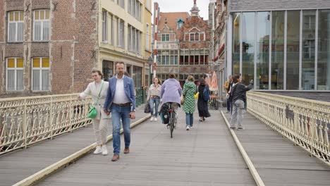 Menschen,-Die-über-Die-Brücke-Im-Oudburg-Viertel-In-Der-Innenstadt-Von-Gent,-Belgien,-Spazieren-Und-Rad-Fahren
