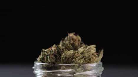 Menschliche-Hand-Nimmt-Eine-Getrocknete-Cannabis-Marihuana-Unkrautknospe-Aus-Einem-Glas-In-Einem-Isolierten-Hintergrund