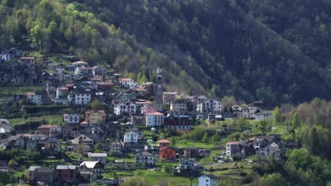 Remote-Villadossola-town-with-clock-tower-in-green-Italian-Alp-hillside