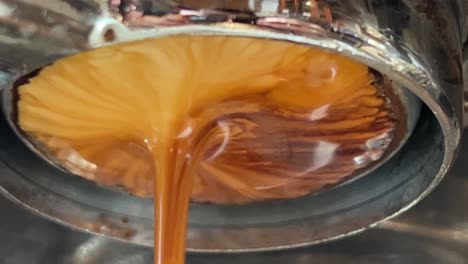 Single-origin-coffee-espresso-extraction-from-coffee-machine-basket,-close-up-shot