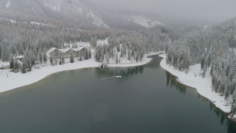 Aerial-view-above-snow-covered-Italian-Lago-Di-Braies-scenic-mountain-alpine-woodland-lake-South-Tyrol