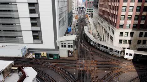Aerial-drone-view-following-a-train-on-the-Wells-Street-in-downtown-Chicago,-USA