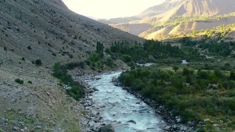 Luftdrohne-Eines-Gletscherflusses,-Der-An-Einem-Nachmittag-Bei-Sonnenuntergang-Im-Sommer-Durch-Die-Berge-Des-Astore-Tals-In-Pakistan-Fließt