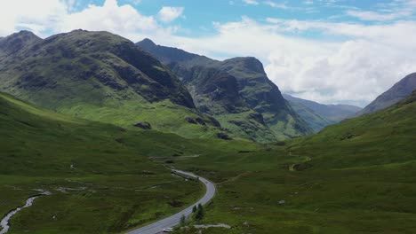 Glen-Coe-and-Three-Sisters-with-A82-road,-aerial,-drone