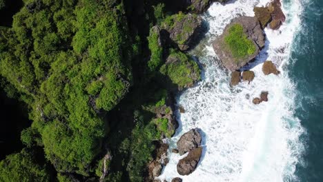 overhead-drone-shot-of-beach-cliff-with-corals-island-hits-by-the-waves