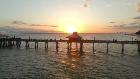 Menschen-Blicken-Auf-Einen-Wunderschönen-Sonnenuntergang-über-Dem-Meer-In-Fort-Myers-Pier,-Florida