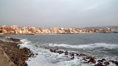 Static-shot-of-waves-hitting-the-rocky-shores-of-a-town-in-San-Bartolo,-Lima,-Peru