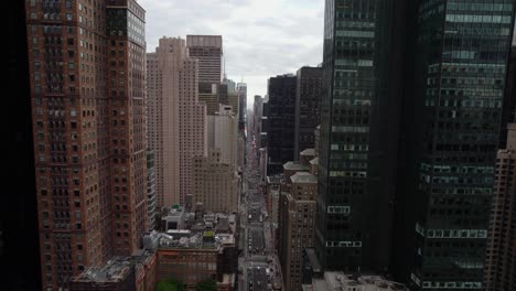 Fliegen-Zwischen-Gebäuden-In-Richtung-Times-Square-Bei-Bewölktem-Himmel,-New-York,-USA---Luftaufnahme