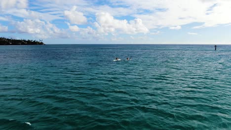Luftaufnahme-Von-Zwei-Männern,-Die-In-Hawaii-Mit-Kanus-Zum-Ufer-Paddeln