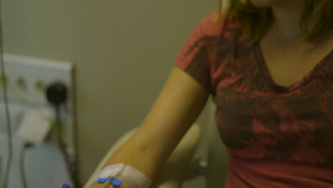 IV-drip-being-connected-and-tilting-up-to-young-woman-in-hospital