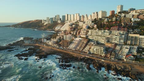 Aerial-view-across-scenic-Avenida-Borgoño-tourism-resorts-cityscape-Reñaca-with-crashing-ocean-waves