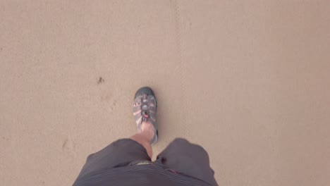 POV-of-man-walking-wearing-shoe-on-white-sand-beach-in-slow-motion-in-summer-holiday-vacation