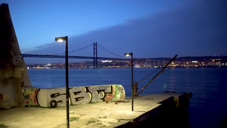 Tagus-river-with-25th-April-Bridge-at-dusk-with-street-lamp-on