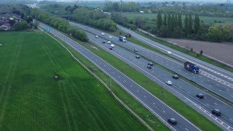 Aerial-view-above-traffic-vehicles-driving-on-busy-UK-highway-lanes