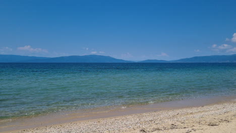 Calm-sea-waves-and-clear-blue-sky-on-a-summer-sunny-day-at-a-Greece-beach