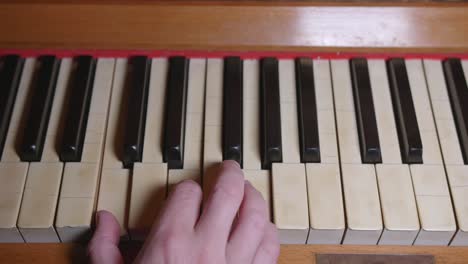 Eine-Hand-Spielt-Zwei-Akkorde-Auf-Einem-Alten-Klavier
