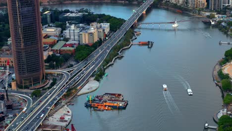 Citycat-Navegando-En-El-Río-Brisbane-Con-Tráfico-En-La-Autopista-Del-Pacífico-En-Brisbane,-Qld,-Australia