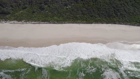 Meereswellen-Mit-Schaum,-Der-Am-Ufer-Des-Seven-Mile-Beach-In-New-South-Wales,-Australien,-Kracht-–-Drohnenaufnahme-Aus-Der-Luft
