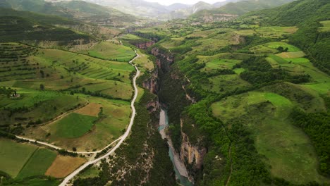 Aerial-scenic-drone-shot-of-the-Osum-Canyon-in-Albania-with-a-river-flowing-through-the-dense-green-foliage-and-forest