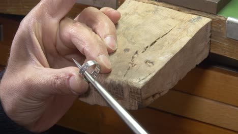 Jeweler-making-ring-using-file-on-a-wooden-block