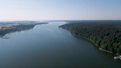 Drone-flyover-aerial-bird-view-of-the-Mikolajskie-lake-near-Mikolajki-in-Poland---A-top-tourist-destination-in-Warmian-Masurian-region-in-north-east-of-Poland---Blue-lake-with-boats-and-blue-sky