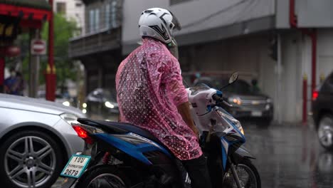 Mann-Fährt-Motorrad-Und-Trägt-Plastikregenmantel,-Chinatown,-Bangkok