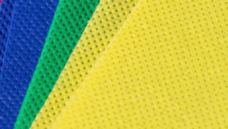 Yellow,-green,-blue-and-red-absorbent-textile-cloth-pieces-macro-shot-close-up-view-with-rotation-motion