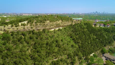 Drone-footage-panning-slowly-from-left-to-right-at-Covert-Park-at-Mount-Bonnell-with-the-city-of-Austin,-Texas-in-the-background