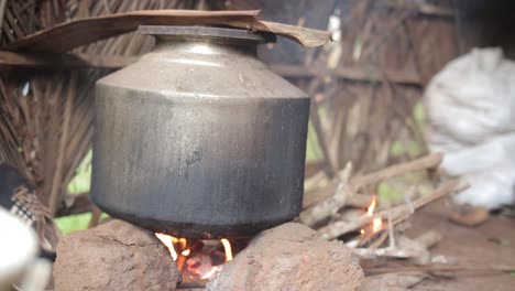 Shot-of-pot-over-campfire-in-hut,-cooking-in-Indian-style