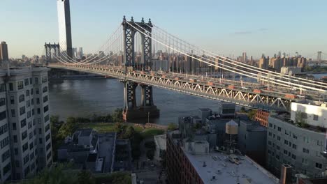 Pushing-drone-shot-of-the-Brooklyn-bridge-located-in-Brooklyn-New-York-during-sunset,-Golden-Hour