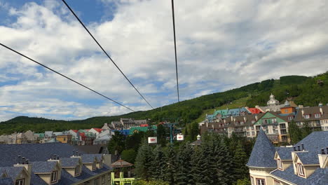 Aerial-Tramway,-Cable-Car-Ropeway-Cabin-View,-Rising-Up-Ascending-over-Mountain-Hotels-in-Mont-Tremblant-Tourist-Destination-Quebec-Canada,-Tourism-and-Sky-Tram-Leisure