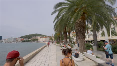 Female-walking-along-the-waters-edge-in-Split,-Croatia