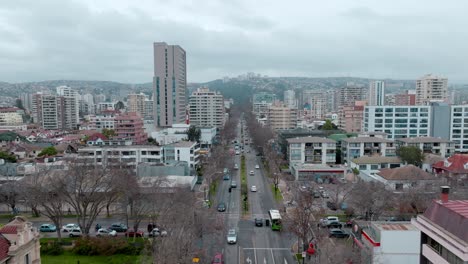 Aerial-drone-forward-shot-of-Libertad-avenue-with-flow-of-vehicles-and-residential-buildings-in-the-city-of-Viña-del-Mar,-chile,-south-america