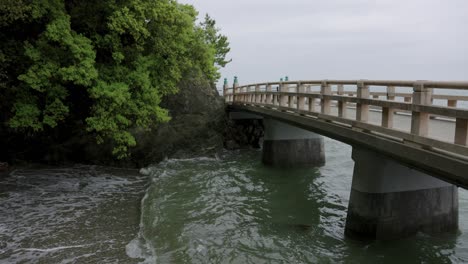 Waves-and-Bridge-through-Meoto-Iwa-Shrine,-Mie-Prefecture-Japan